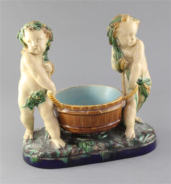 A Victorian Minton majolica group of two putti carrying a wooden tub, width 28cm height 27cm